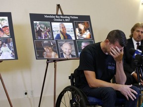 Jason McMillan, 36, of Riverside, a Riverside County Sheriff's deputy who was shot and paralyzed in the Oct, 1, 2017, Las Vegas shooting, reacts as he talks about that evening and is upset MGM's decision, during a personal account brought together by attorneys at a news conference in Newport Beach, Calif., Monday, July 23, 2018. Behind McMillan are images of the shooting victims of the October 1, 2017 shooting. Victims of the fatal mass shooting at a Las Vegas country music festival are outraged they are being sued by MGM, which owns the hotel where the gunman opened fire.