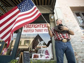 Charles Phillips waits for a procession carrying the body of firefighter Braden Varney on Monday, July 16, 2018, in Mariposa, Calif. Varney died Saturday while battling the Ferguson fire when his bulldozer overturned.