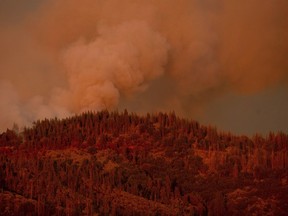 FILE - In this Monday, July 16, 2018, file photo, the Ferguson Fire burns along a ridgeline in unincorporated Mariposa County, Calif. Officials said Saturday, July 21, 2018, that the Ferguson fire is churning northward, sending up smoke that has been obscuring valley views in the park.