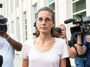 Clare Bronfman is surrounded by reporters as she leaves Federal court, July 24, 2018, in Brooklyn, New York.