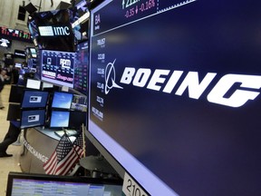 The Boeing logo appears above a trading post on the floor of the New York Stock Exchange on July 24, 2017. The global aerospace landscape will again change as Boeing Co. announced a planned tie-up with Embraer SA that could put pressure on Bombardier Inc. and its C Series joint venture with Airbus. Boeing will own 80 per cent of the joint venture valued at US$4.75 billion and Embraer the remaining 20 per cent.