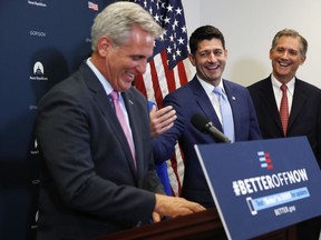 House Speaker Paul Ryan of Wis., center, jokes with House Majority Leader Kevin McCarthy of Calif., left, during a news conference following a GOP caucus meeting, Tuesday, July 24, 2018, on Capitol Hill in Washington. At right is Rep. French Hill, R-Arkansas.