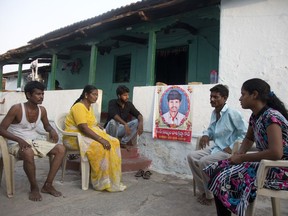 FILE - In this May 25, 2018 file photo, family member grieve by a portrait of Bala Krishna, a 33-year-old motorized rickshaw driver who was killed by a mob inflamed by social media in Jiyapalli village, outside his house at Korremula village, on the outskirts of Hyderabad, India. India's government has on Tuesday, July 3, asked WhatsApp to take immediate action to prevent the social media site from being misused to spread rumors and irresponsible statements like those blamed for recent deadly mob attacks. At least 20 people have been killed in mostly rural villages in many Indian states, victims who were innocent people accused in the viral messages of belonging to gangs trying to abduct children.