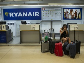 A Portuguese woman, who preferred not to give her name, sits at a Ryanair airline check-in desk after her flight to Pisa, Italy, was cancelled during the first of two days cabin crew strike at Adolfo Suarez-Barajas international airport in Madrid, Wednesday, July 25, 2018. Low-cost airline Ryanair cabin crew are to stage a 48-hour strike July 25 and 26 in Spain, Portugal, Italy and Belgium.
