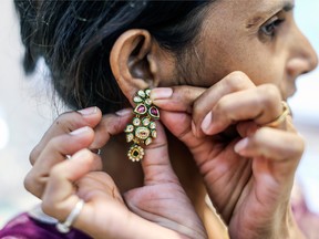 A customer tries on a gold earring at a jewelry store in Mumbai, India. The country's appetite for the precious metal seems to be abating as imports slump.