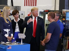 President Donald Trump participates in a tour of an advanced manufacturing lab with Ivanka Trump, second from left, and Gov. Kim Reynolds, R-Iowa, third from left, at Northeast Iowa Community College, Thursday, July 26, 2018, in Peosta, Iowa.