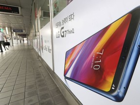 A visitor walks by an advertisement of LG Electronics at an electronic shop area in Seoul, South Korea, Thursday, July 26, 2018. LG Electronics says its second-quarter net profit has dropped 43 percent as its mobile business has logged a bigger loss.