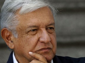 In this Sunday, July 22, 2018 photo, Mexico's President-elect Andres Manuel Lopez Obrador listens to a reporter's question outside his party's headquarters, in Mexico City.  Lopez Obrador announced a $16 billion investment plan Friday, July 27, 2018, to boost flagging oil production, refinery capacity and electrical generation.