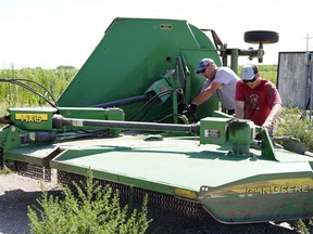 Tim Novotny, right, works with Loran Houska, both of Wahoo, Neb., perform maintenance on a farm shredder in Wahoo, Neb., Tuesday, July 24, 2018. The Trump administration announced Tuesday it will provide $12 billion in emergency relief to ease the pain of American farmers slammed by President Donald Trump's escalating trade disputes with China and other countries.