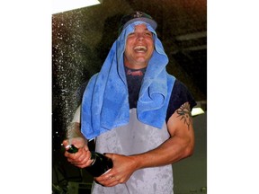 FILE - In this Sept. 26, 1999, file photo, Atlanta Braves Chipper Jones stands on a table to spray teammates after beating the Montreal Expos 10-0 to clinch the NL East title, in Montreal. Jones will be inducted into the Baseball Hall of Fame on Sunday, July 29, 2018.