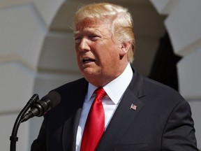 FILE - In this July 27, 2018, file photo, President Donald Trump delivers remarks on the economy from the South Lawn of the White House, in Washington. Trump met with the publisher of The New York Times to discuss media coverage of his administration, including the president's oft-repeated accusation that the media is the "enemy of the people," Trump and the newspaper said Sunday, July 29, 2018. The meeting with A.G. Sulzberger occurred July 20, the White House and Times said.