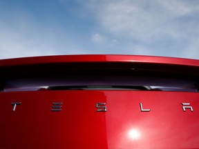 FILE - In this April 15, 2018, file photo, the sun shines off the rear deck of a roadster on a Tesla dealer's lot in the south Denver suburb of Littleton, Colo. Tesla stock is sinking Monday, July 23, after the Wall Street Journal reported that the company asked suppliers for refunds to help it turn a profit.