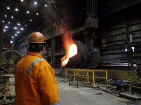 FILE- In this Thursday, June 28, 2018, file photo senior melt operator Randy Feltmeyer watches a giant ladle as it backs away after pouring its contents of red-hot iron into a vessel in the basic oxygen furnace as part of the process of producing steel at the U.S. Steel Granite City Works facility in Granite City, Ill. On Monday, July 2, the Institute for Supply Management, a trade group of purchasing managers, issues its index of manufacturing activity for June.