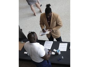 In this Thursday, June 21, 2018 photo, Gregory Johnson fills out an application for Custom Services at a job fair hosted by Job News South Florida, in Sunrise, Fla. On Tuesday, July 10, the Labor Department reports on job openings and labor turnover for May.