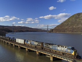 FILE- In this April 26, 2018, file photo, a CSX Transportation locomotive pulls a train of tank cars across a bridge on the Hudson River along the edge of Bear Mountain State Park, near Fort Montgomery, N.Y. CSX railroad will give investors another update on its efforts to cut costs and improve efficiency when it releases its quarterly earnings report on Tuesday, July 17, 2018.