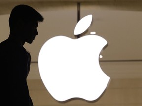 In this May 31, 2018, photo, a customer enters the Apple store in New York. Apple made more money from higher priced iPhones in the latest quarter, even as unit sales were relatively unchanged. Shares of Apple rose nearly 3 percent Tuesday, July 31, after it reported fiscal third-quarter results that beat Wall Street expectations.