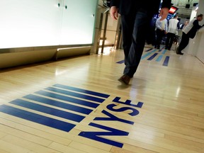 FILE- In this April 5, 2018, file photo, an NYSE logo adorns the entrance to the trading floor the New York Stock Exchange. Never has it been so cheap to put money into the market, and it's about to get even cheaper following Vanguard's recent decision to end online commissions for most ETFs.