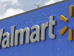 FILE - This June 1, 2017, file photo, shows a Walmart sign at a store in Hialeah Gardens, Fla. Google spinoff Waymo says it's launching a pilot program with Walmart that will allow customers to use its self-driving car service to pick up groceries at Walmart stores. Waymo said in a blog post on Wednesday, July 25, 2018 that the program, which will be tested in Phoenix, will help make shopping more convenient.