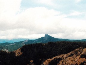 FILE - In this July 6, 2000, file photo, Pilot Rock rises into the clouds in the Cascade-Siskiyou National Monument near Lincoln, Ore. Contrary to President Donald Trump's numerous efforts to shred Obama's legacy, U.S. Justice Department lawyers are in Obama's corner as they defend his expansion of the national monument in Oregon.