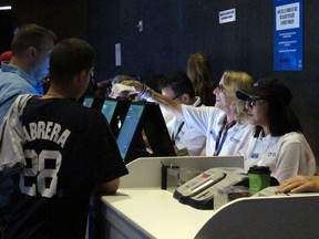 In this Saturday, July 14, 2018 photo a clerk hands a sports betting ticket to a gambler at the Meadowlands Racetrack in East Rutherford N.J., minutes after it started accepting sports bets. FanDuel Group says it plans to offer sports betting for the track, and a full internet casino operation in time for the start of football season in September. Sports betting in New Jersey began last month, generating $16.4 million in bets during its first two weeks.