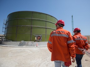 Workers walk past a gas storage tank at the constriction site of the Trans Adriatic Pipeline receiving terminal in Melendugno, Italy. The Trans-Adriatic Pipeline, known as TAP, is a a 4.5 billion-euro ($5.2 billion) natural gas pipeline that will bring gas from Azerbaijan, winding through Greece and Albania, under the Adriatic Sea and finally up into Italy, which imports more than 90 per cent of its oil and gas.