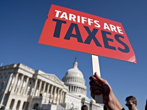 A "Tariffs Are Taxes" sign is held during a protest agains potential U.S. auto tariffs on Capitol Hill in Washington on July 19.