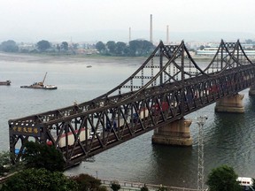 FILE - In this Sept. 4, 2017, file photo, trucks cross the friendship bridge connecting China and North Korea in the Chinese border town of Dandong, opposite side of the North Korean town of Sinuiju.  China's imports from North Korea plunged 92.6 percent in June, 2018, compared with a year earlier under U.N. sanctions imposed to stop Pyongyang's nuclear and missile programs, the customs agency said Friday, July 13, 2018.