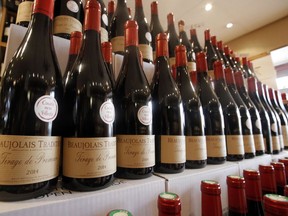 In this Nov. 20, 2014, file photo, bottles of Beaujolais Nouveau wine are displayed in a wine store at Issy Les Moulineaux, outskirts of Paris. The European Union and Japan are signing a widespread trade deal Tuesday, July 17, 2018, that will eliminate nearly all tariffs, seemingly defying the worries about trade tensions set off by U.S. President Donald Trump's policies. Prices of European wine and pork will fall for Japanese consumers.