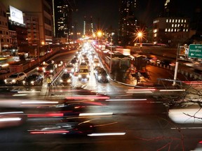 FILE- In this Jan. 11, 2018, file photo, cars pass the Queensboro Bridge in New York. The Trump administration is citing safety to justify freezing gas mileage requirements. A draft of a regulation prepared this summer would freeze an Obama-era program to improve fuel efficiency and cut pollution.