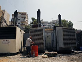 This Monday, July 16, 2018, photo shows Mamdouh al-Amari oiling privately-owned diesel generators that provide power to homes and businesses, in the southern suburbs of Beirut, Lebanon. Lebanon received a floating power station from Turkey this week to ease the rolling blackouts that are a feature of its sticky summers. The 235-megawatt Esra Sultan, built and operated by the private Turkish company Karadeniz Energy, was billed by Energy and Water Minister Cesar Abi Khalil as a temporary but thrifty measure to bridge part of Lebanon's chronic electricity deficit.