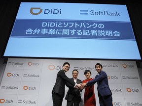 Vice President of Strategy at Didi Chuxing Stephen Zhu, left, CEO and President of Softbank Mobile Corp. Ken Miyauchi, second left, President of Didi Chuxing Jean Liu, second right, and deputy division head at Softbank Mobile Keigo Sugano shake hands during a press conference announcing their joint venture in Tokyo Thursday, July 19, 2018.