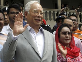 Former Malaysian Prime Minister Najib Razak and his wife Rosmah Mansor wave to their supporters as they exit the High Court of Malaya, in Kuala Lumpur, Malaysia, Monday, July 9, 2018. Najib was charged last Wednesday with criminal breach of trust and corruption, two months after a multibillion-dollar graft scandal at a state investment fund led to his stunning election defeat.