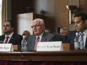 FILE - In this May 8, 2018 file photo, Walter Higgins, Chief Executive Office, Puerto Rico Electric Power Authority, center, addresses the Senate Committee on Energy and Natural Resources on Capitol Hill in Washington, flanked by Christian Sobrino-Vega, left, director of the Government Development Bank for Puerto Rico and Jose H. Roman Morales, president of Puerto Rico's Energy Commission. Higgins resigned on Wednesday, July 11, 2018, months after he was chosen to oversee the privatization of the bankrupt power company that is struggling to restore electricity after Hurricane Maria.