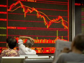Chinese investors monitor stock prices at a brokerage house in Beijing, Friday, July 6, 2018. President Donald Trump made clear Thursday that U.S. tariffs against Chinese imports will take effect early Friday and that he's prepared to sharply escalate a trade war between the world's two biggest economies.