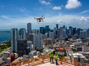John Murphy, left, and Larry Shueneman of Coastal Construction fly a drone over a construction site at the Miami Worldcenter.