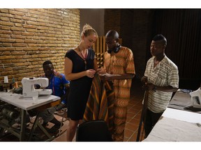 From left, Bakary Bamba, 26, from Ivory Coast, Lydia Witt, 35, from Ohio, Daouda Doumbia, 26, from Ivory Coast and Lassina Coulibaly, 19, from Mali work at The Sewing Cooperative nonprofit organization, in Rome, Monday, Aug. 13, 2018. After a decade working as a dressmaker for the New York City Ballet and Broadway productions, Lydia Witt moved to Rome to channel her passion in a new direction. Last year she started a small organization to employ skilled migrant tailors, mainly from West African countries.