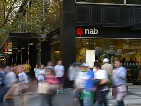 Pedestrians walk past a National Australia Bank Ltd. (NAB) branch in Melbourne.