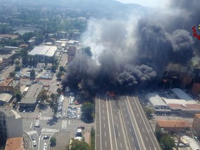 In this photo released by the Italian firefighters, an helicopter view of the explosion on a highway in the outskirts of Bologna, Italy, Monday, Aug. 6, 2018. The explosion was reportedly caused by an accident involving a truck that was transporting flammable substances and exploded upon impact. (Vigili Del Fuoco via AP)