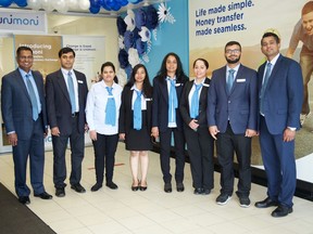 Ajit Paul, Regional Head-APAC (extreme left) and Rajesh Pazhassi Veettil, Country Head of Unimoni Canada (extreme right), with the staff during the launch of Unimoni brand in Canada.