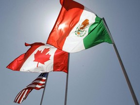 National flags of the United States, Canada, and Mexico fly in the breeze in New Orleans. The hurry-up-and-wait uncertainty surrounding Canada's return to the NAFTA talks is entering a new week as Ottawa's partners in the trilateral deal push forward with their one-on-one negotiations.