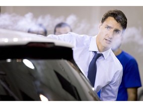 Prime Minister Justin Trudeau uses a smoke wand during a demonstration of air flow over a car during a visit to the University of Ontario's Institute of Technology in Oshawa, Ont. on Friday August 31, 2018.