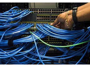 Canada's telecom regulator says the average household spent nearly $223 every month on communications services, including mobile phones, landlines, Internet and cable TV in 2016. Networking cables in a server bay are shown in Toronto on Wednesday, November 8, 2017.