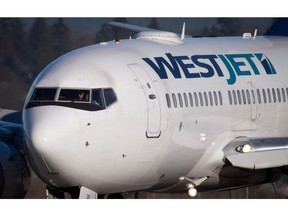 A pilot taxis a Westjet Boeing 737-700 plane to a gate after arriving at Vancouver International Airport in Richmond, B.C., on February 3, 2014.