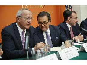 Mexican Secretary of Economy Ildefonso Guajardo, center, speaks to Jesus Seade, left, designated chief negotiator of Mexican President-elect Andres Manuel Lopez Obrador, as Mexican Foreign Minister Luis Videgaray, far right, speaks during a news conference at the Mexican Embassy in Washington, Monday, Aug. 27, 2018. The Trump administration and Mexico have reached a preliminary accord to end the North American Free Trade Agreement and replace it with a deal that the administration wants to be more favorable to the United States.