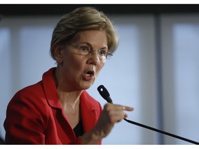 Sen. Elizabeth Warren, D-Mass., gestures while speaking at the National Press Club in Washington, Tuesday, Aug. 21, 2018. Warren wants a lifetime ban on members of Congress from getting hired as lobbyists after they leave public office. She also wants to prohibit lawmakers from owning or trading individual stocks while in office.