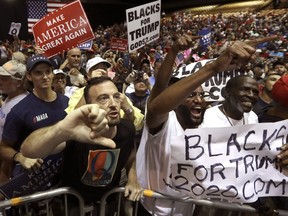 FILE In this Tuesday, July 31, 2018, file photo, supporters of President Donald Trump shout down a CNN news crew before a rally in Tampa, Fla. Amid the "Trump 2020" placards, the "Women for Trump" signs and the "CNN SUCKS" T-shirts, the most inscrutable message that came out of Donald Trump's Tampa rally on Tuesday evening was a letter, Q.