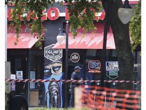 A police officer walks by the front of a Chicago Pizza and GLHF Game Bar on Monday, Aug. 27, 2018, at the scene of fatal shooting on Sunday, at The Jacksonville Landing in Jacksonville, Fla. A gunman opened fire at a video game tournament killing multiple people and then fatally shooting himself in a rampage that wounded several others.