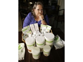 In this Nov. 14, 2017, photo, Patricia Rodgers poses with Herbalife products in Hallandale Beach, Fla. Rodgers and others are suing the multi-level marketing company that sells its products through a network of distributors who recruit more distributors. Los Angeles-based Herbalife, a publicly traded company with 2017 net sales of $4.4 billion, has long been embroiled in litigation and regulatory actions over its business practices, which have been compared by some to a pyramid scheme.