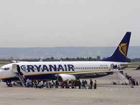 FILE - In this Wednesday, May 13, 2015 file photo passengers disembark a Ryanair plane, at the Marseille Provence airport, in Marignane, southern France. German Ryanair pilots will go on a 24-hours strike on Friday, Aug. 10, 2018 in Germany.