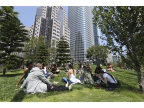 In this photo taken Wednesday, Aug. 15, 2018, employees from marketing company Linqia have a picnic lunch on the rooftop park of the new Transbay Transit Center in San Francisco. The new $2.2 billion center opened earlier this month.